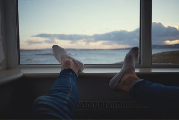 A person 's feet are up on the ledge of a boat.