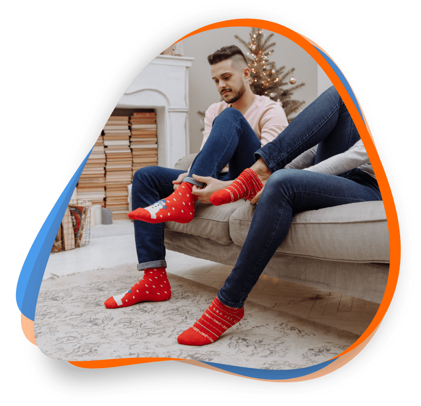 A man sitting on the couch wearing red socks.