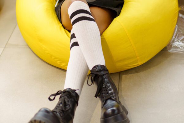 A person wearing black and white socks sitting on the ground