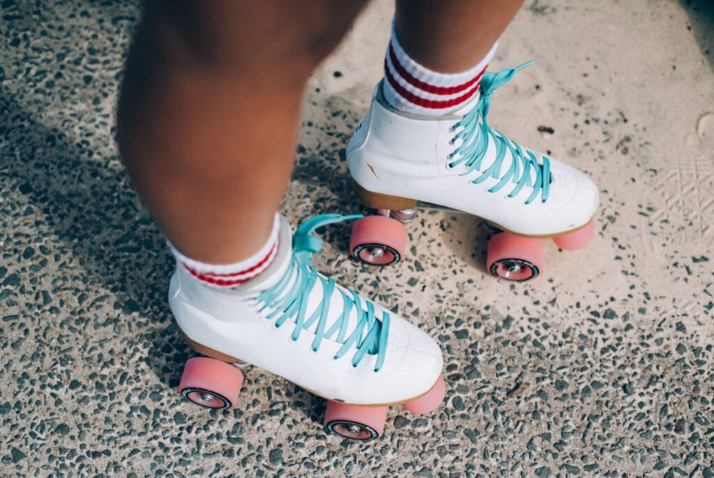 A person wearing white and blue roller skates.